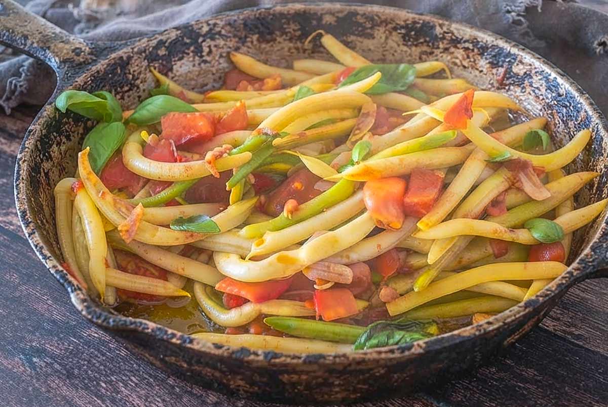 Greek-Style Yellow Beans with Garlic and Tomatoes simmering in a skillet