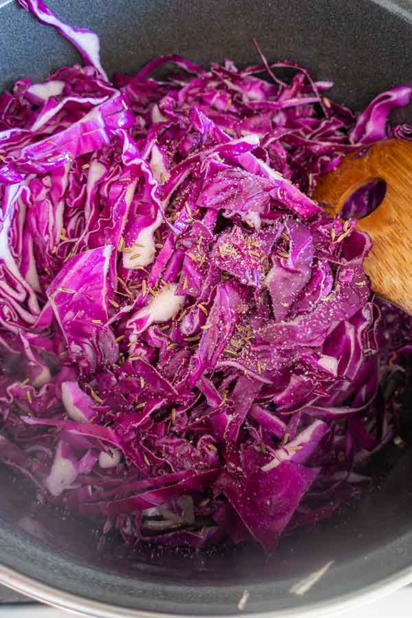 shredded red cabbage with caraway and seasoning in a bowl
