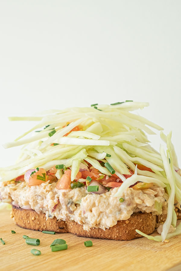 salmon salad sandwich topped with coleslaw