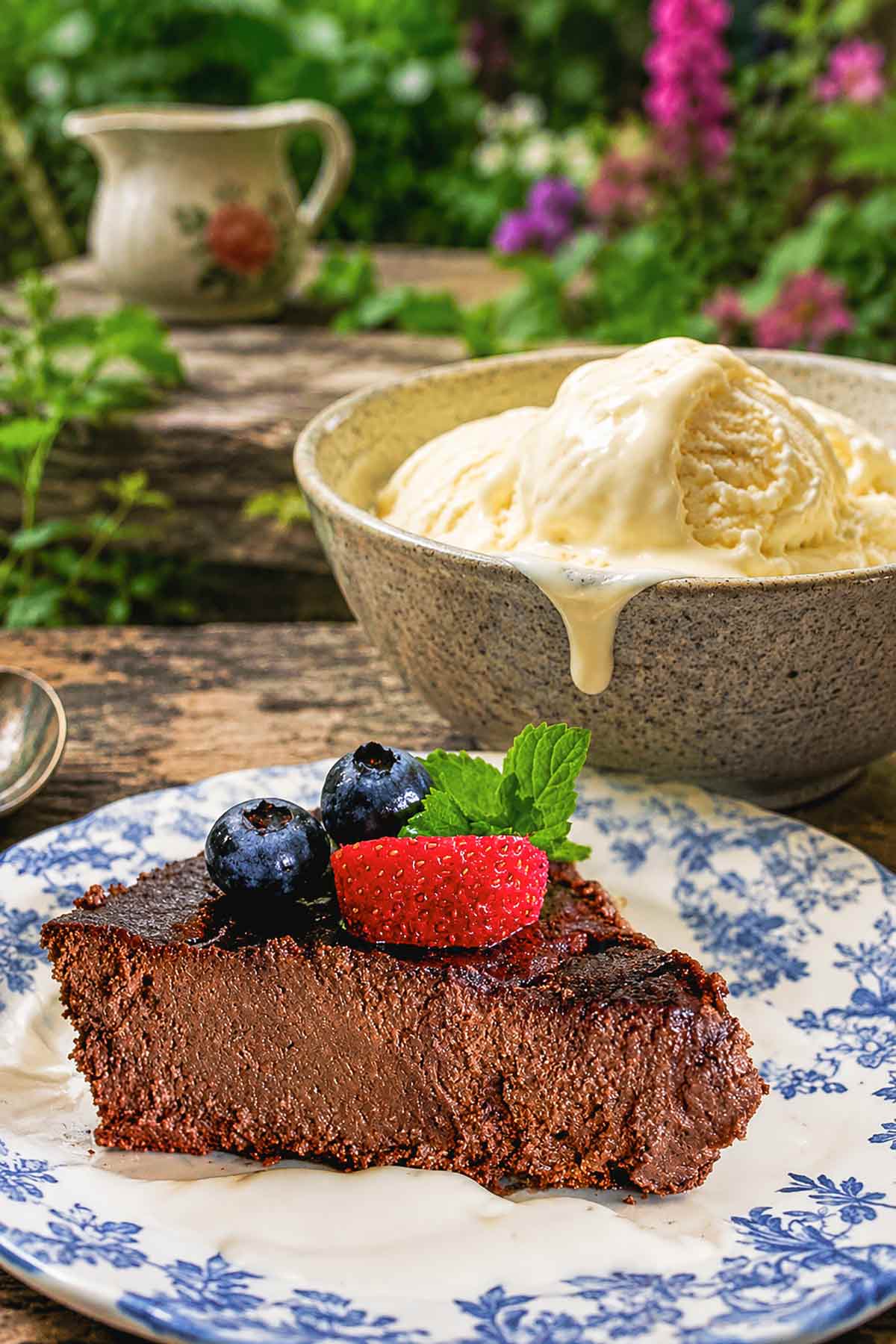 Slice of flourless chocolate walnut pie on a plate showing its rich, fudgy, mousse-like texture topped with berries