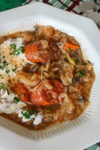 sauerkraut soup in a bowl with sausage, carrots, mushrooms and sour cream