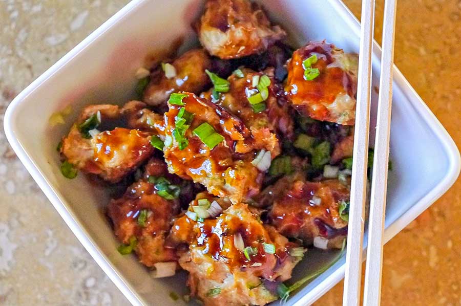 asian meatballs in a bowl with chopsticks