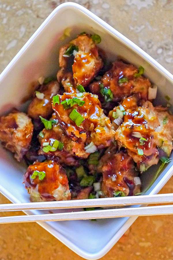 Asian meatballs in a bowl with chopsticks