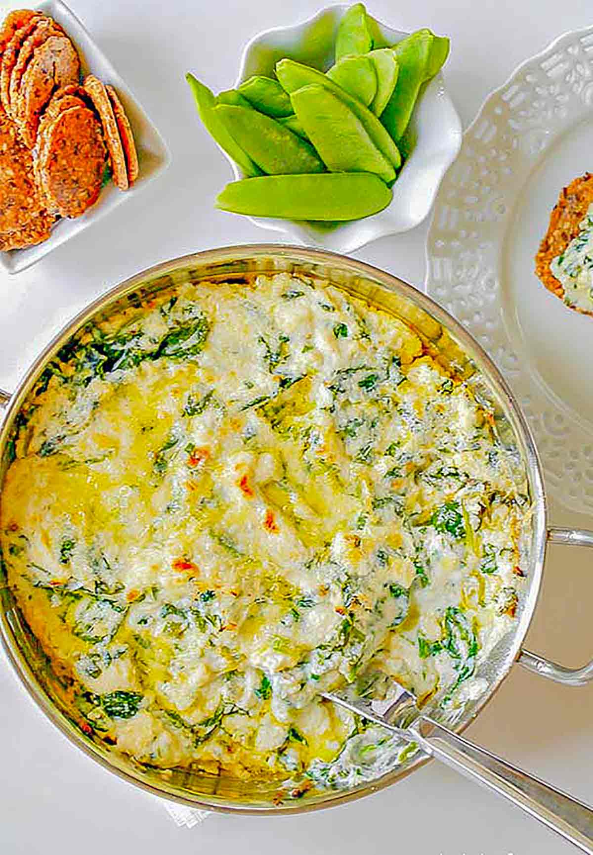 baked spinach ricotta dip in a bowl with a spoon