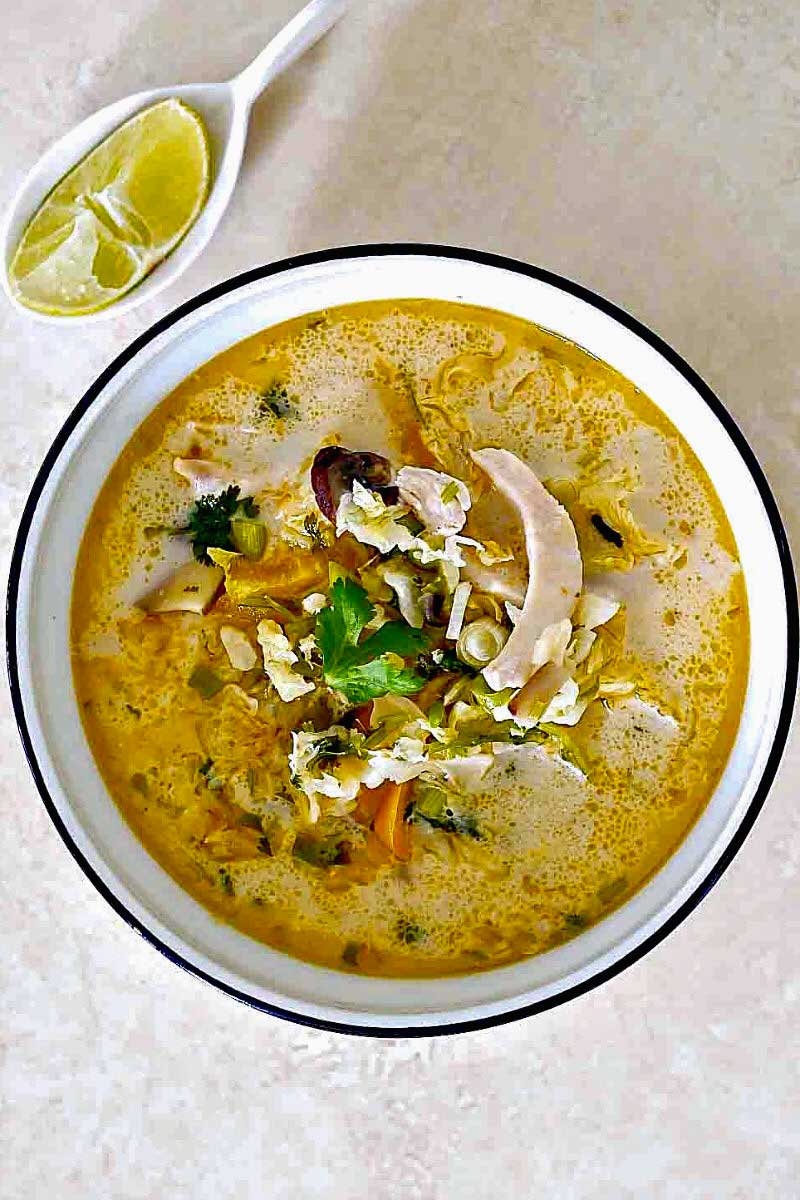 Spicy Thai Coconut Chicken Soup with Vegetables and a side of lime wedge