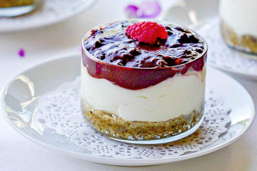 gluten-free cheesecake cup with layers of cheeecake, chocolate and walnut crust