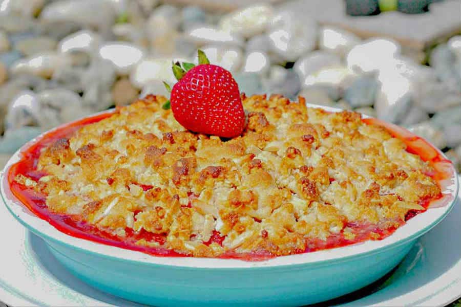 baked paleo strawberry pie in a pie dish topped with a strawberry