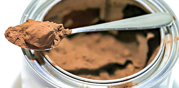 cocoa powder on a spoon in a can