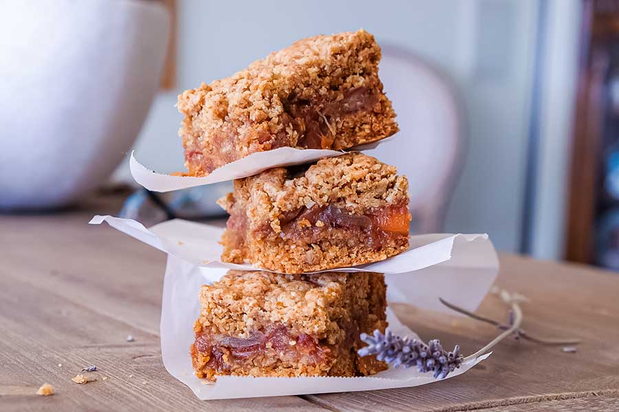 3 stacked gluten free date bars on parchment paper