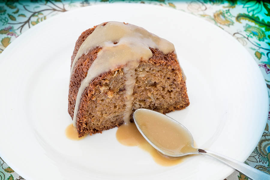 a slice of walnut snacking cake with vanilla sauce on a plate 