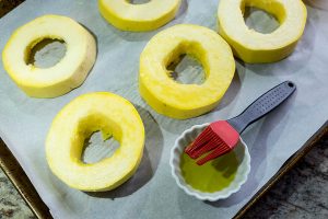 slices of uncooked spaghetti squash on a baking sheet