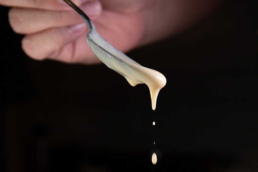 vanilla sauce dripping from a teaspoon
