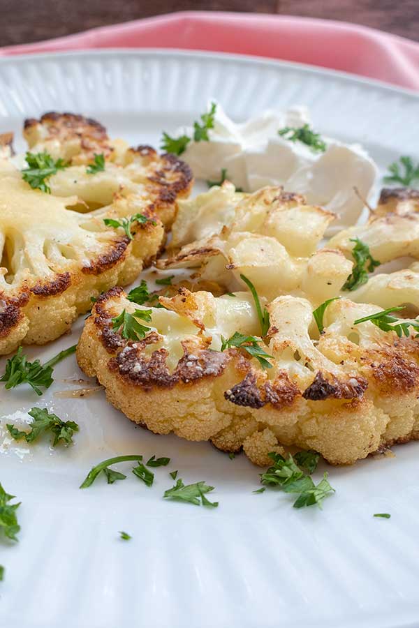 2 cauliflower steaks on a plate