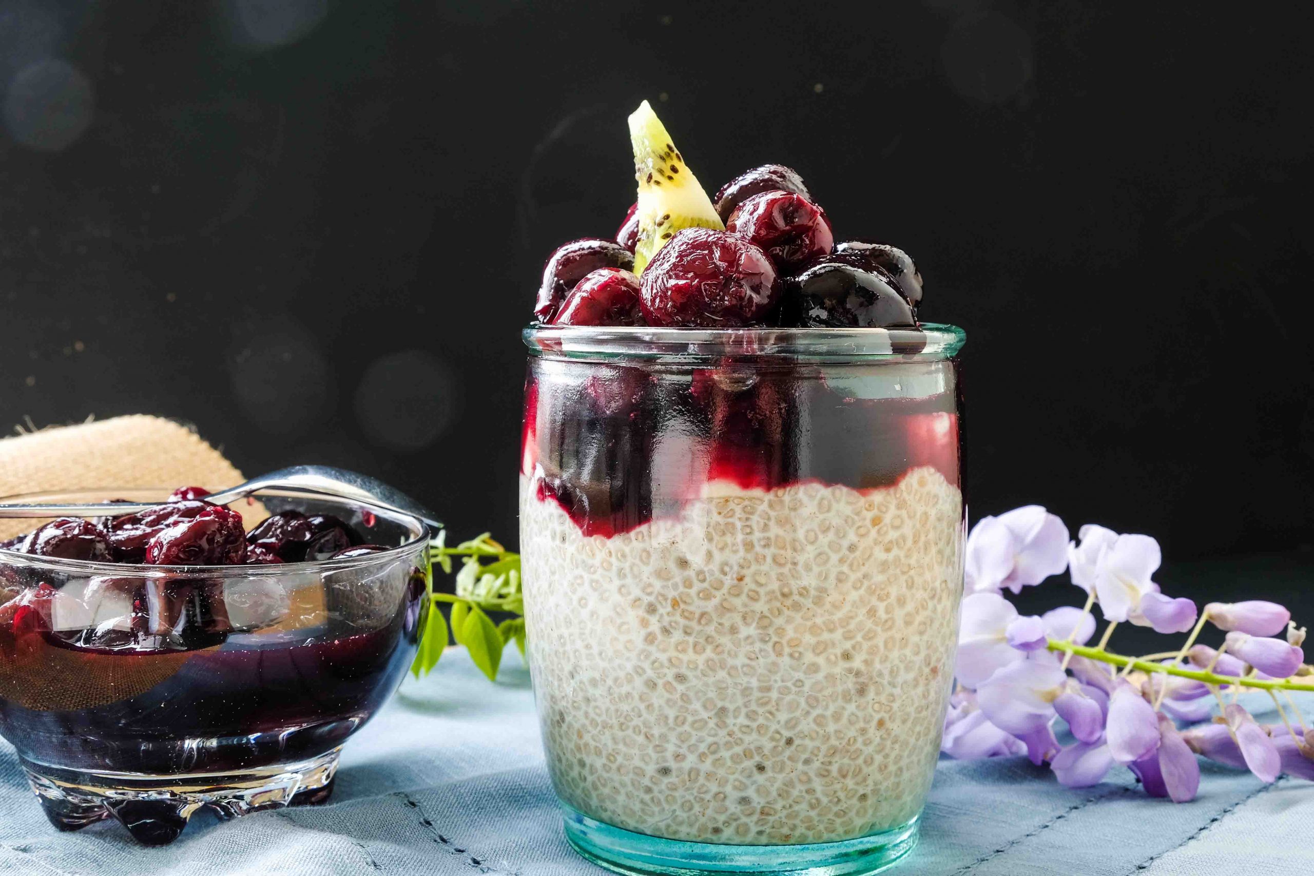 dairy free chia breeakfast in a glass topped with cherries
