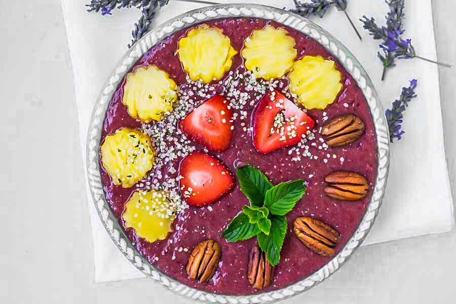 pineapple chia smoothie in a bowl topped with fruit