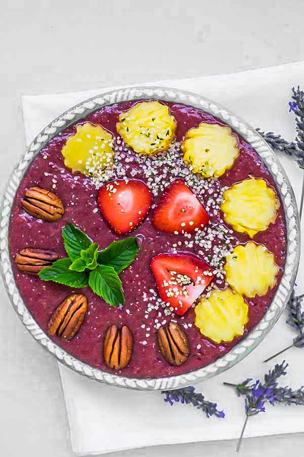 pineapple chia smoothie in a bowl topped with fruit