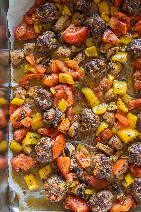 roasted veggies with meatballs on a baking sheet