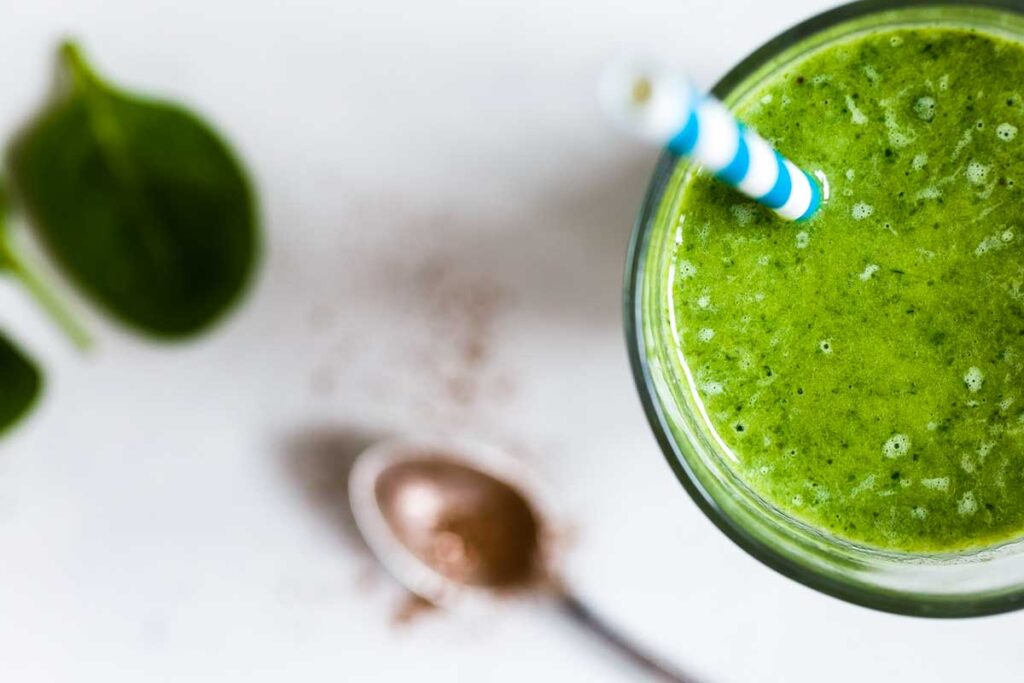 glass of apple juice with spinach and celery