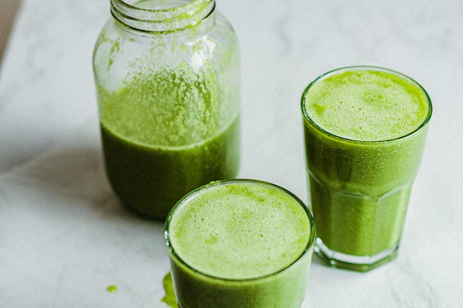 citrus green juice for acne in two glasses and a jar