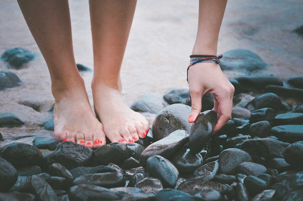 showing feet walking on pebbles