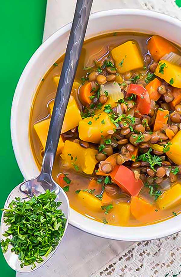lentil butternut squash soup in a bowl with a spoon, vegan