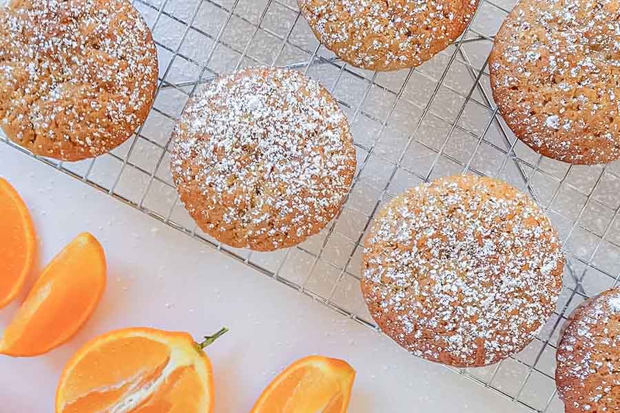 orange muffin on a cooling rack with orange slices