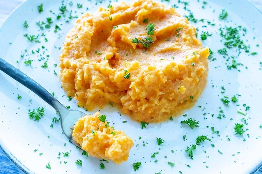 turnip carrot mash garnished with parsley on a plate