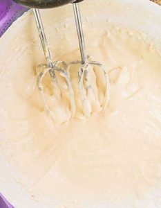 whipping royal cream cheese frosting in a bowl, gluten free