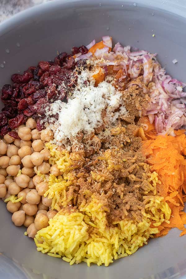 rice, raisins, chickpeas, carrots, red onions, herbs and spices in a bowl