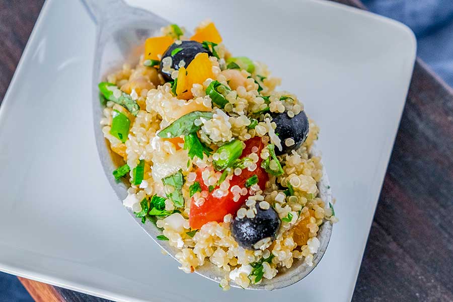 Greek quinoa salad on a spoon