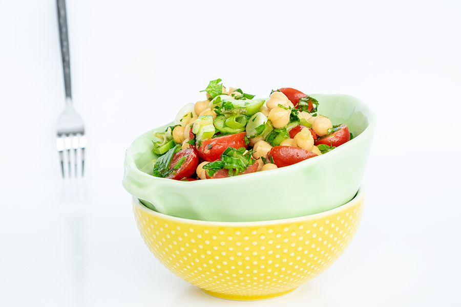 two bowls stacked with chickpea tomato and cucumber salad