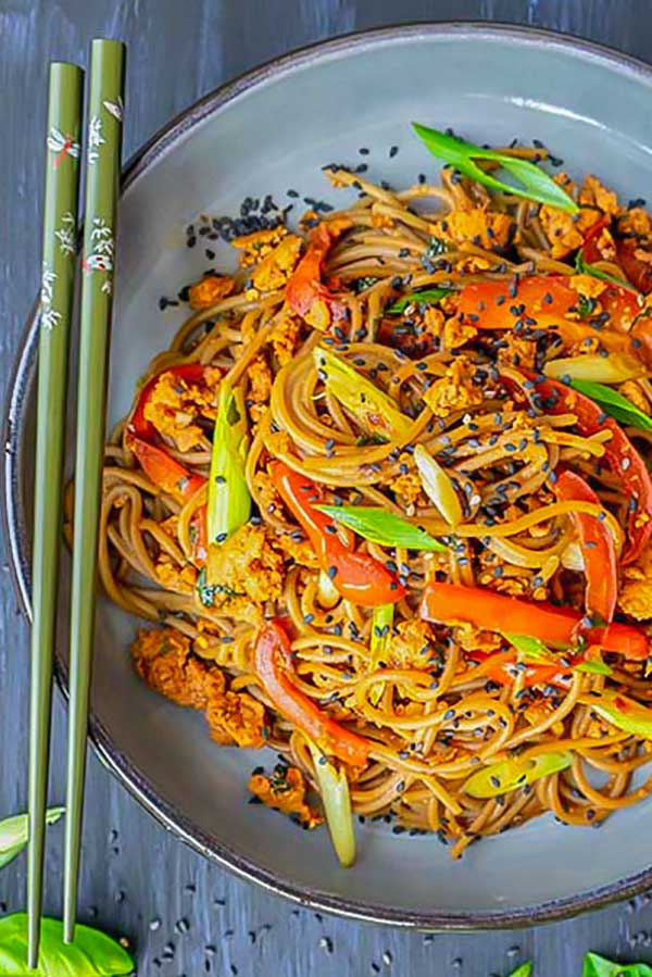 soba noodles with chicken on a plate with chopsticks