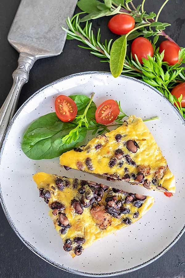 two pieces of one pan breakfast with veggies and sausage on a plate