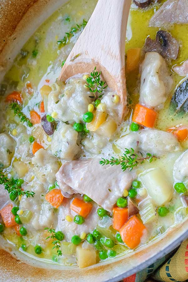 top view of chicken stew with a wooden spoon