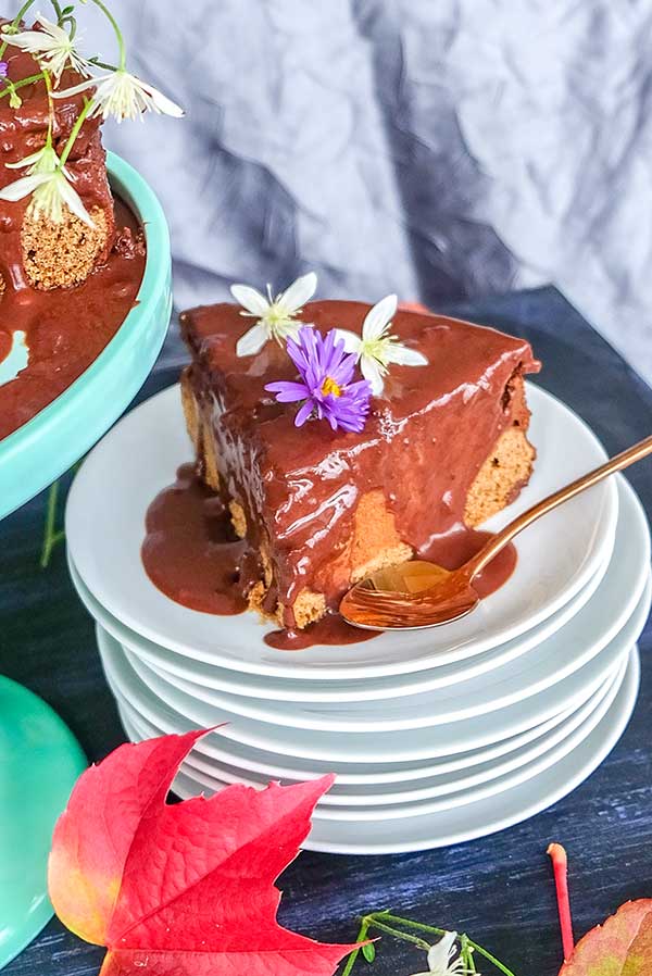 a slice of chocolate pumpkin cake with ganache topping on a plate, gluten free