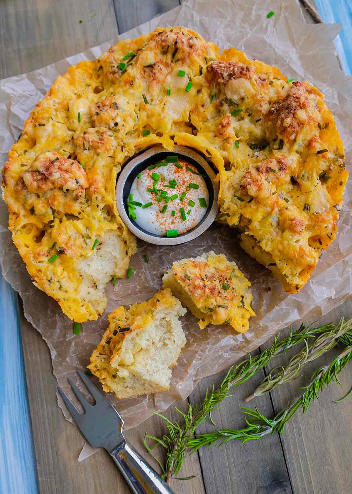 gluten free garlic cheese monkey bread torn into pieces with a dip in the middle