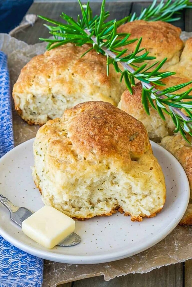 pull apart gluten free sort rolls with rosemary showing one on a small plate with butter