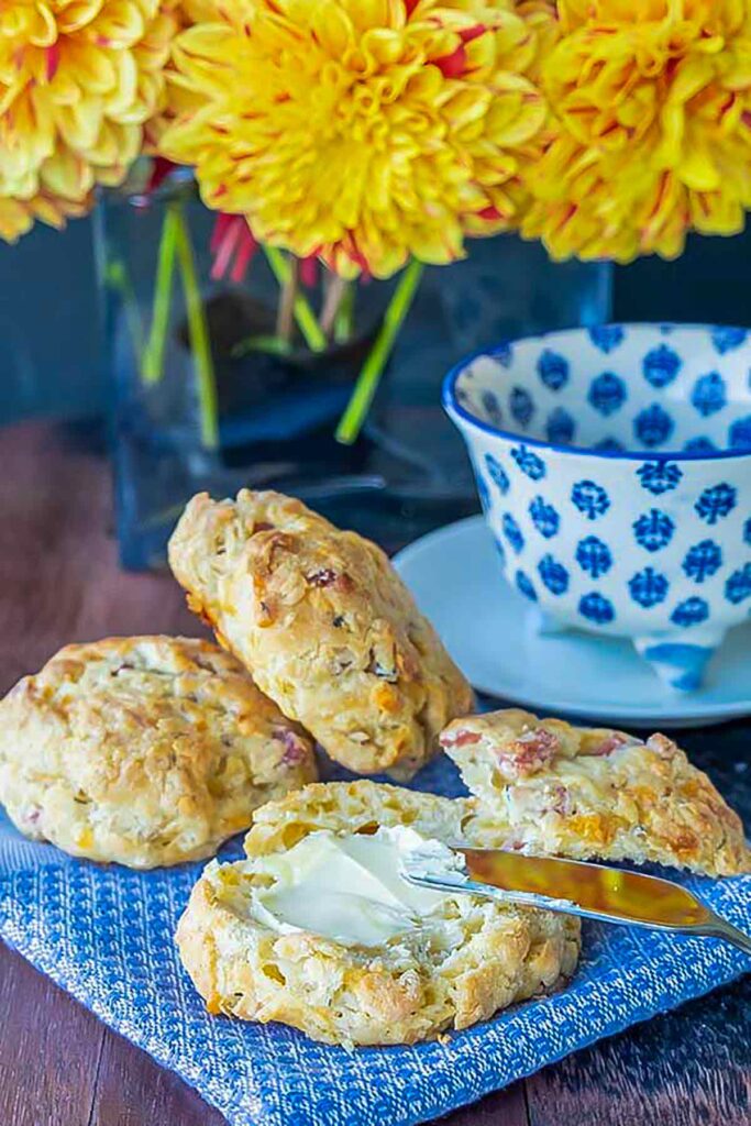 gluten free ham and cheese biscuits topped with butter on a napkin