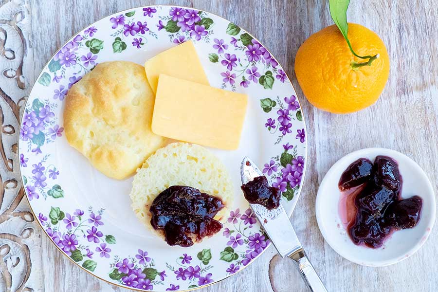 english muffin on a plate with butter and jam