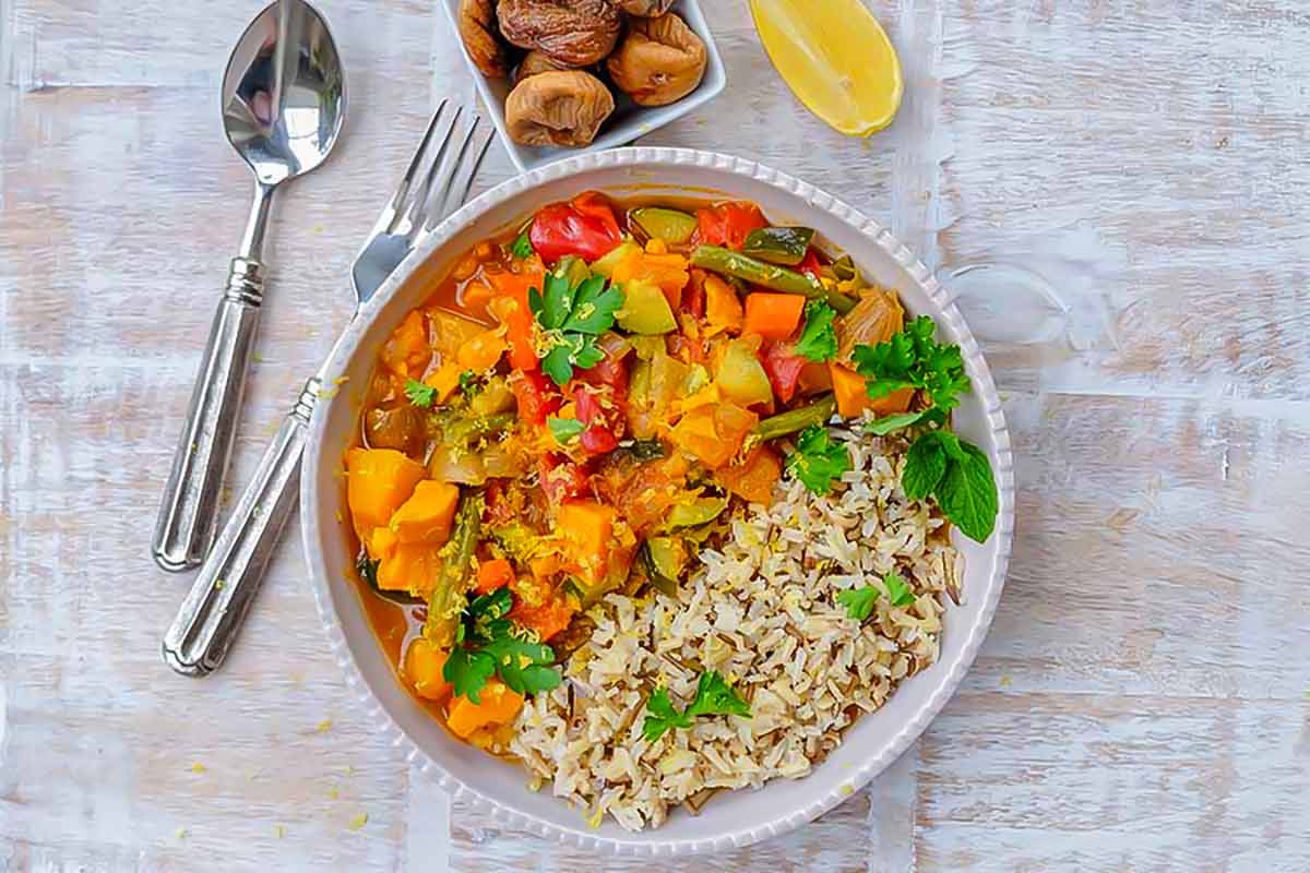 serving Moroccan vegetable stew with rice and lemon wedge