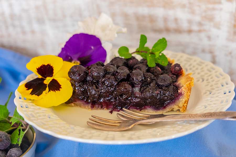 a slice fo gluten free vegan blueberry tart on a plate