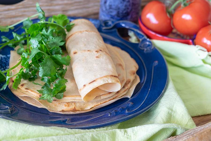gluten-free tortilla on a plate with fresh herbs