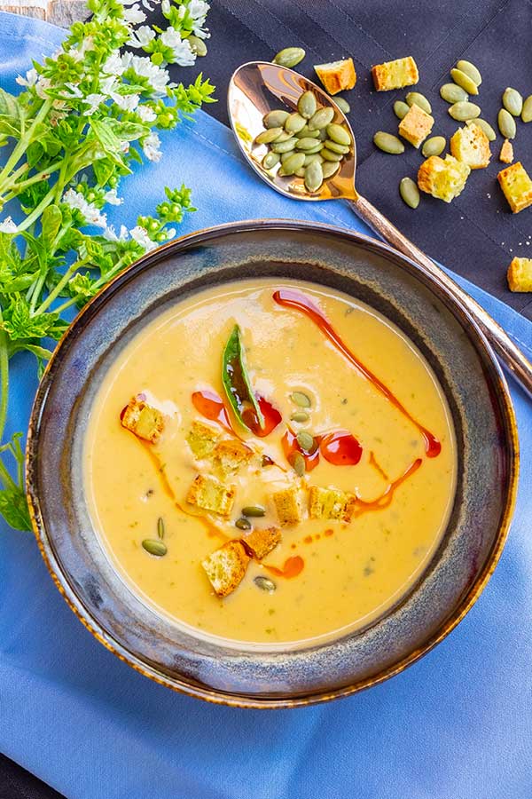 buffalo sweet potato soup in a bowl drizzled with hot sauce