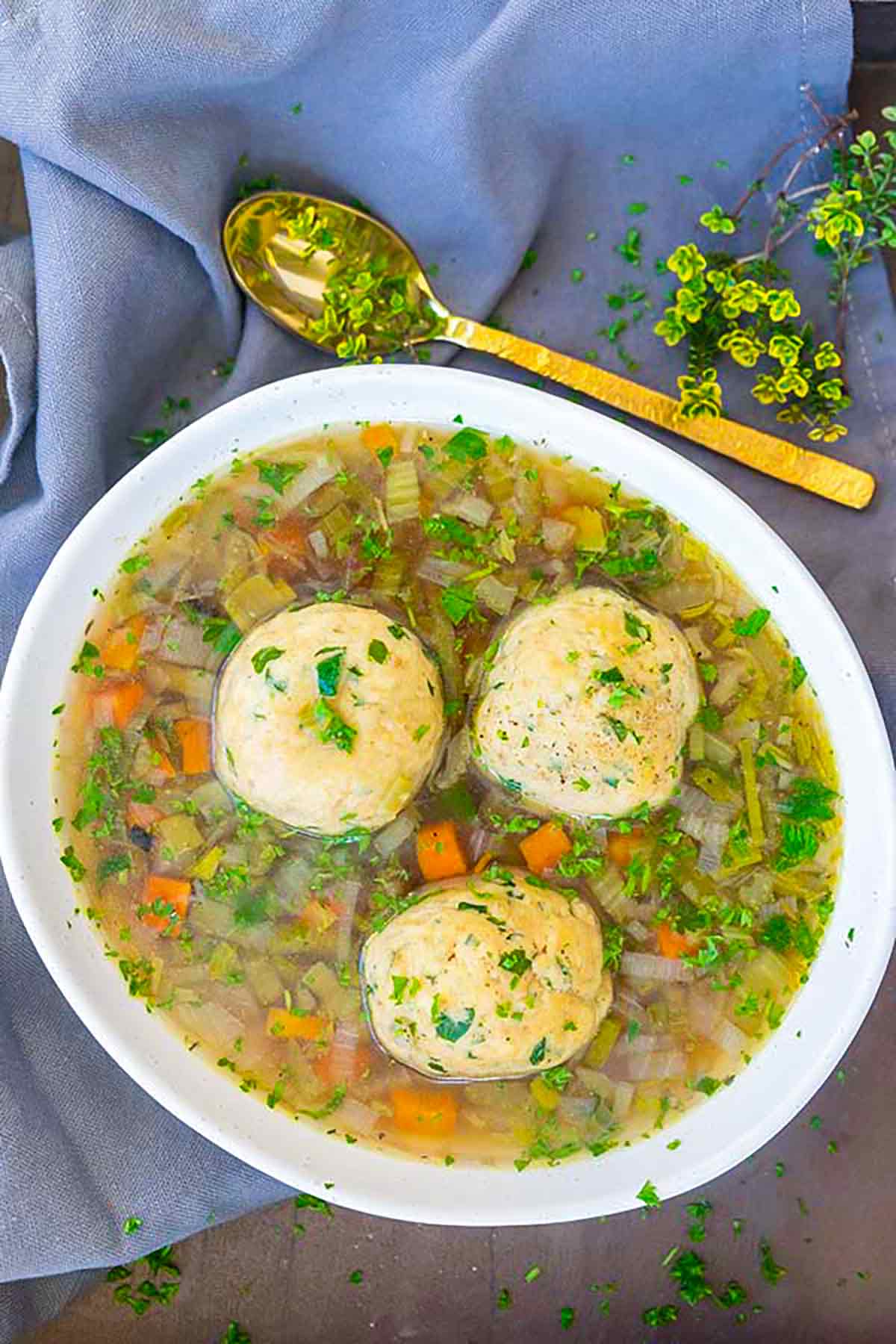 a bowl of matzo ball soup garnished with parsley