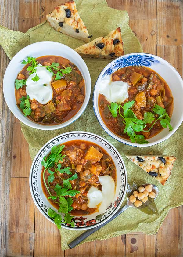 vegan chickpea chili with toppings in three bowls