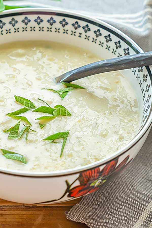 bowl of keto cauliflower soup topped with fresh sage