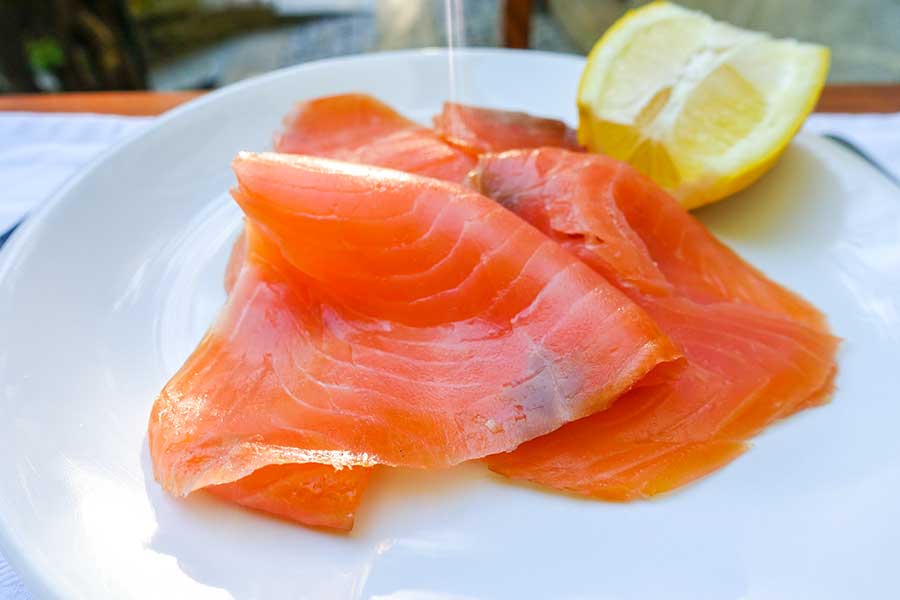 smoked salmon with a lemon slice on a plate