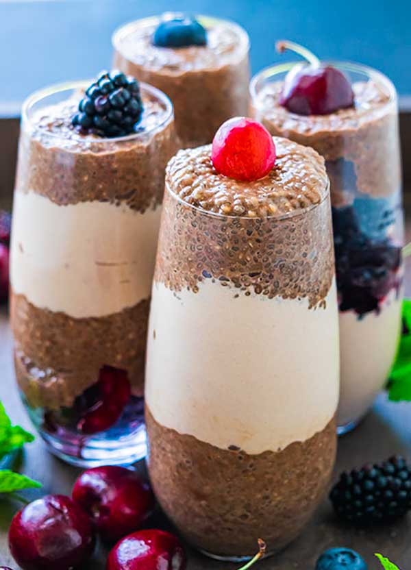 mocha chia pudding in 4 glasses topped with berries