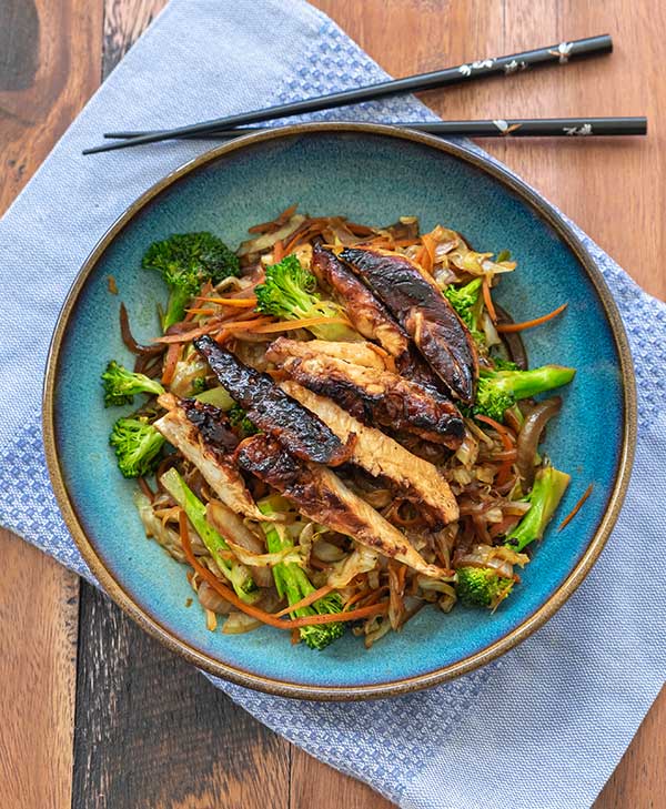 plated asian chicken salad with chop sticks on the side