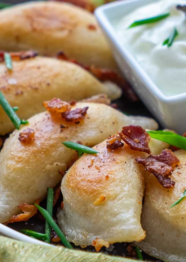 gluten-free perogies topped with bacon on a plate